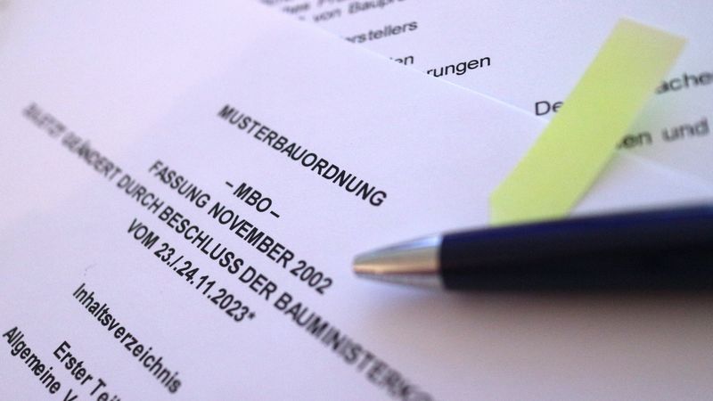 Ein Bild von einer Detailaufnahme der Musterbauordnung , mit einem Stift darauf platziert.